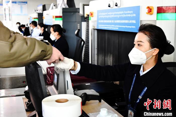 圖為機(jī)場工作人員為旅客辦理行李托運(yùn)。　周航 攝