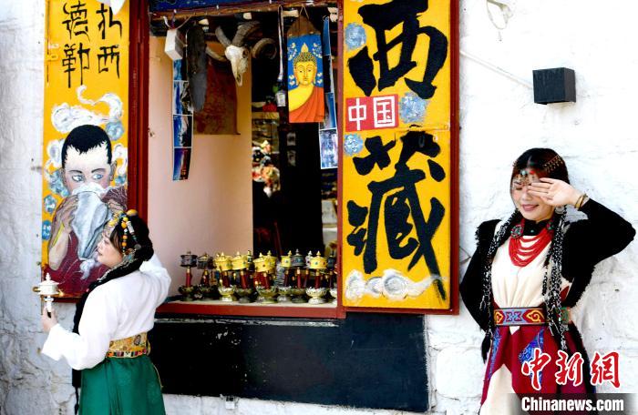 4月17日，游客身著藏式元素服裝在拉薩八廓街拍照留念?！±盍?攝