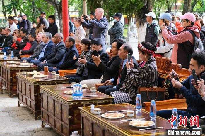 5月19日，中外嘉賓在羅布林卡和游客一起觀看藏戲?！〗w波 攝