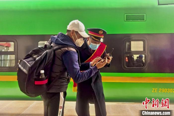 圖為日喀則火車站工作人員服務(wù)乘客。　斗山得 攝