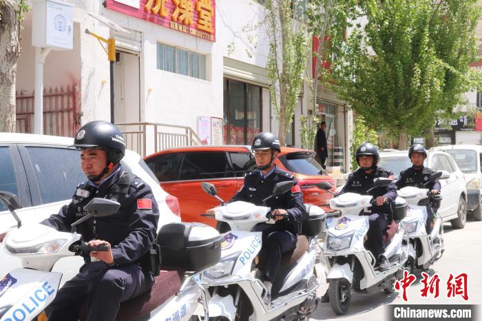 民警騎著電瓶車(chē)在轄區(qū)巡邏走訪?！↑S創(chuàng)偉 攝