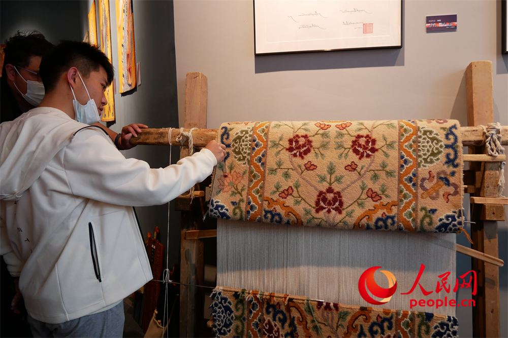 觀眾正在觀賞展出的藏毯。人民網(wǎng) 韋衍行攝