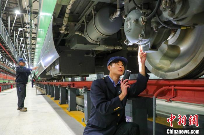 圖為工作人員檢查高原復(fù)興號(hào)?！≈軔傁?攝