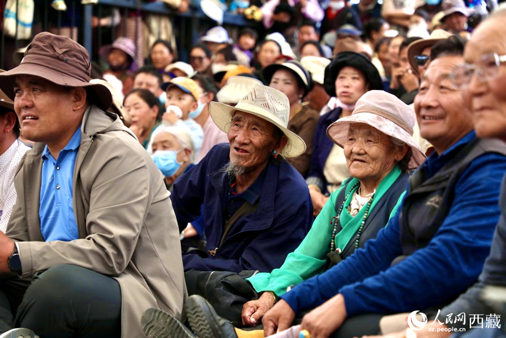 當(dāng)?shù)厝罕姾陀慰陀^看藏戲演出。