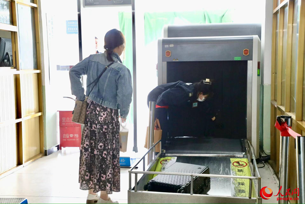 車站工作人員幫旅客提取行李。人民網(wǎng)記者 次仁羅布攝