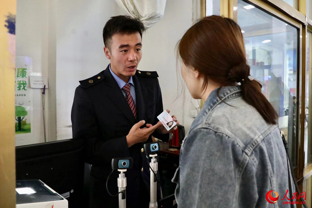 車站工作人員向旅客解答疑問。人民網(wǎng)記者 次仁羅布攝