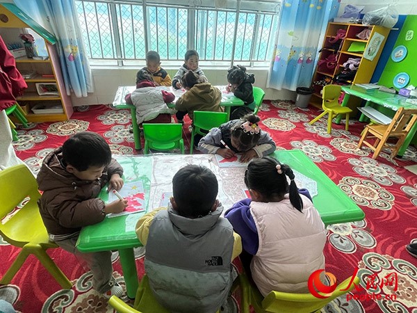 拉多村一所現(xiàn)代化幼兒園小班孩子們正在繪畫。張敏穎 攝