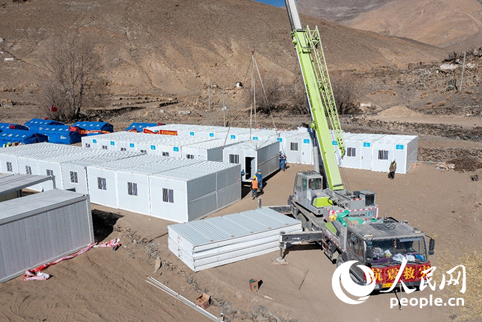 1月9日，在日喀則市定日縣長(zhǎng)所鄉(xiāng)古榮村安置點(diǎn)，救援人員和施工人員合力抓緊搭建移動(dòng)板房，確保受災(zāi)群眾溫暖過(guò)冬。人民網(wǎng)記者 翁奇羽攝