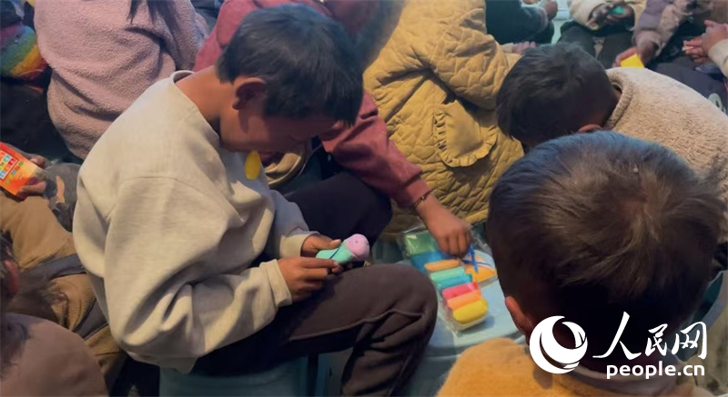 措果鄉(xiāng)塘仁村的孩子們正在用橡皮泥制作自己的情緒“小怪獸”。人民網(wǎng)記者 郝潔攝