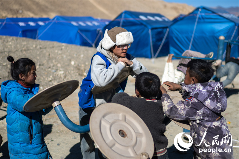 西藏星光社會(huì)工作服務(wù)中心社工久米旦增通過(guò)聊天談心，對(duì)孩子們進(jìn)行災(zāi)后心理疏導(dǎo)。人民網(wǎng)記者 翁奇羽攝
