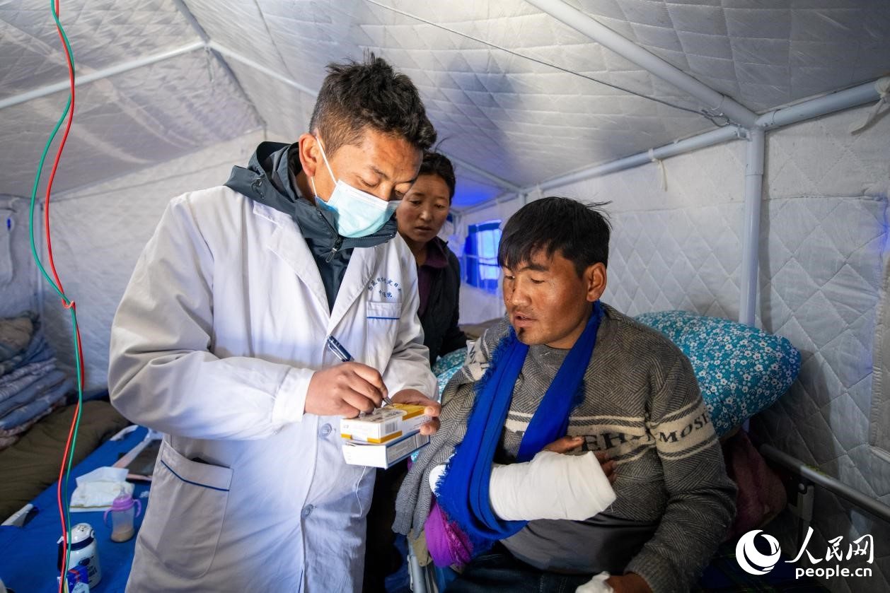 　醫(yī)生正在囑咐洛桑堅(jiān)參如何用藥。人民網(wǎng)記者 翁奇羽攝