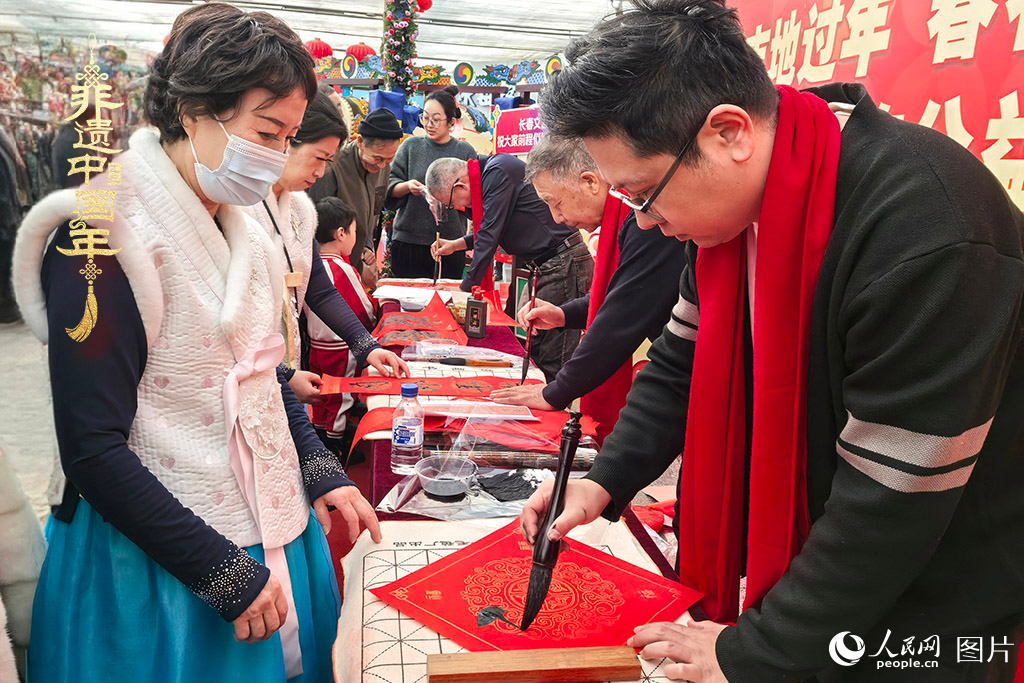 新春佳節(jié)之際，長春農博園冬季展會火熱進行，展廳內，書法家現場書寫“?！弊?，市民游客紛紛上前迎春接“福”。人民網記者 王海躍攝