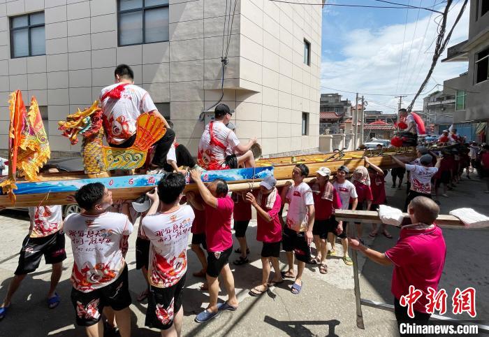 圖為5月29日，長樂江田鎮(zhèn)村民們肩扛著新龍舟舉行入水前游街儀式?！埍?攝