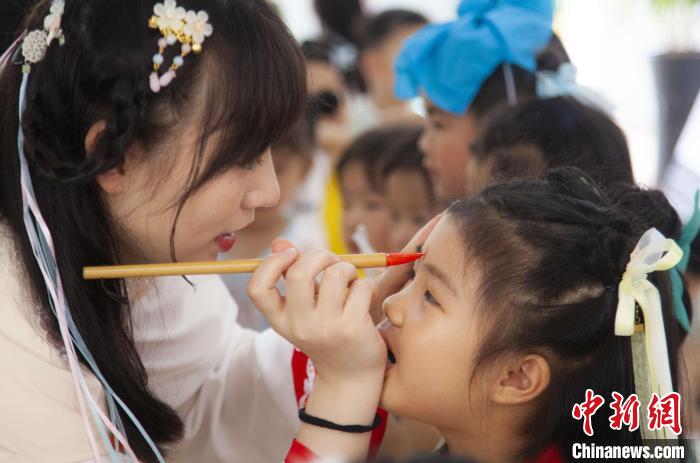圖為老師在孩子們額頭上點(diǎn)上雄黃，驅(qū)邪辟禍。　董觀生 攝