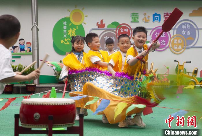 圖為龍舟賽游戲上，小伙伴們打鼓加油?！《^生 攝